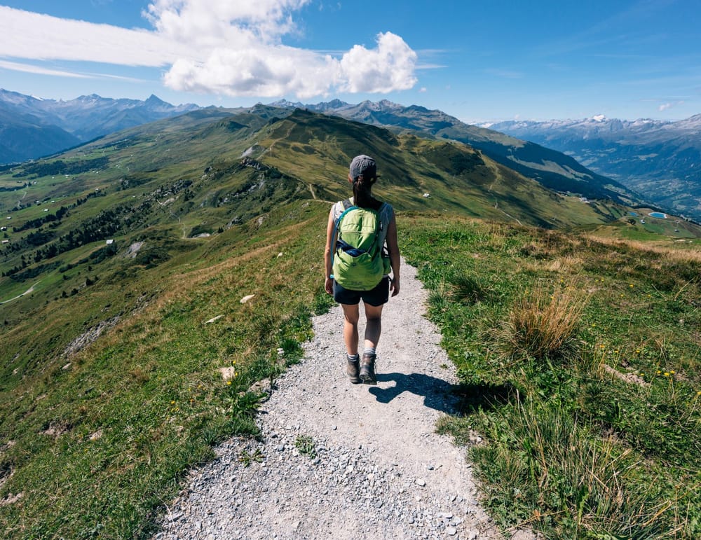 Flacher, gerader Wanderweg im Sommer mit Wanderer