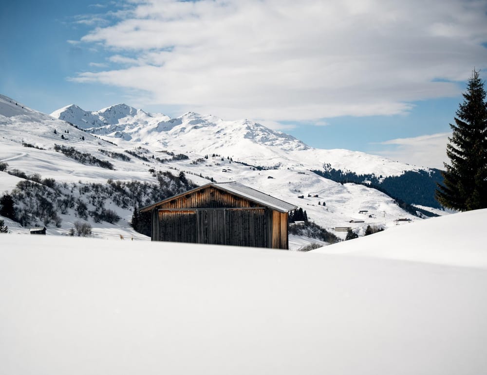 Maiensäss in Schneehügeln im Hintergrund Winterlandschaft