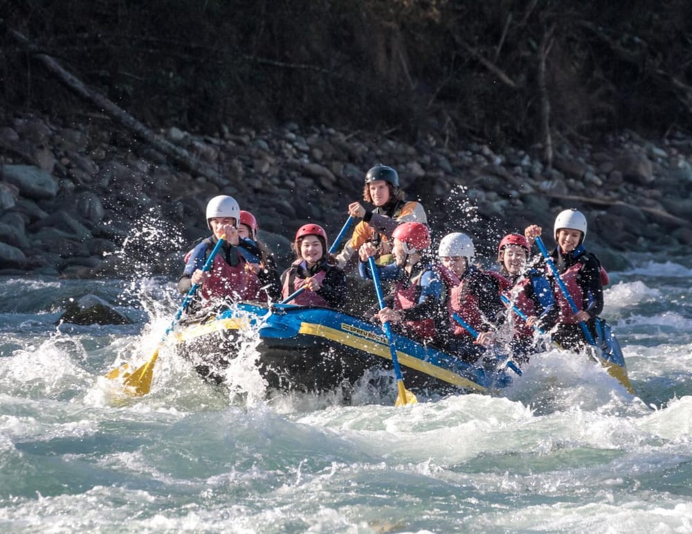 Rafting mit Schlauchboot und vielen Personen an Board auf dem Rhein