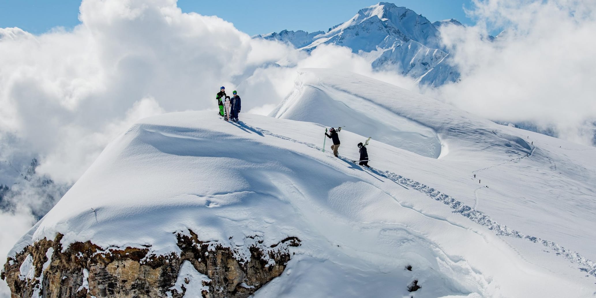 Skitourengänger im Schnee auf Berg vor blauem Himmel in der Surselva