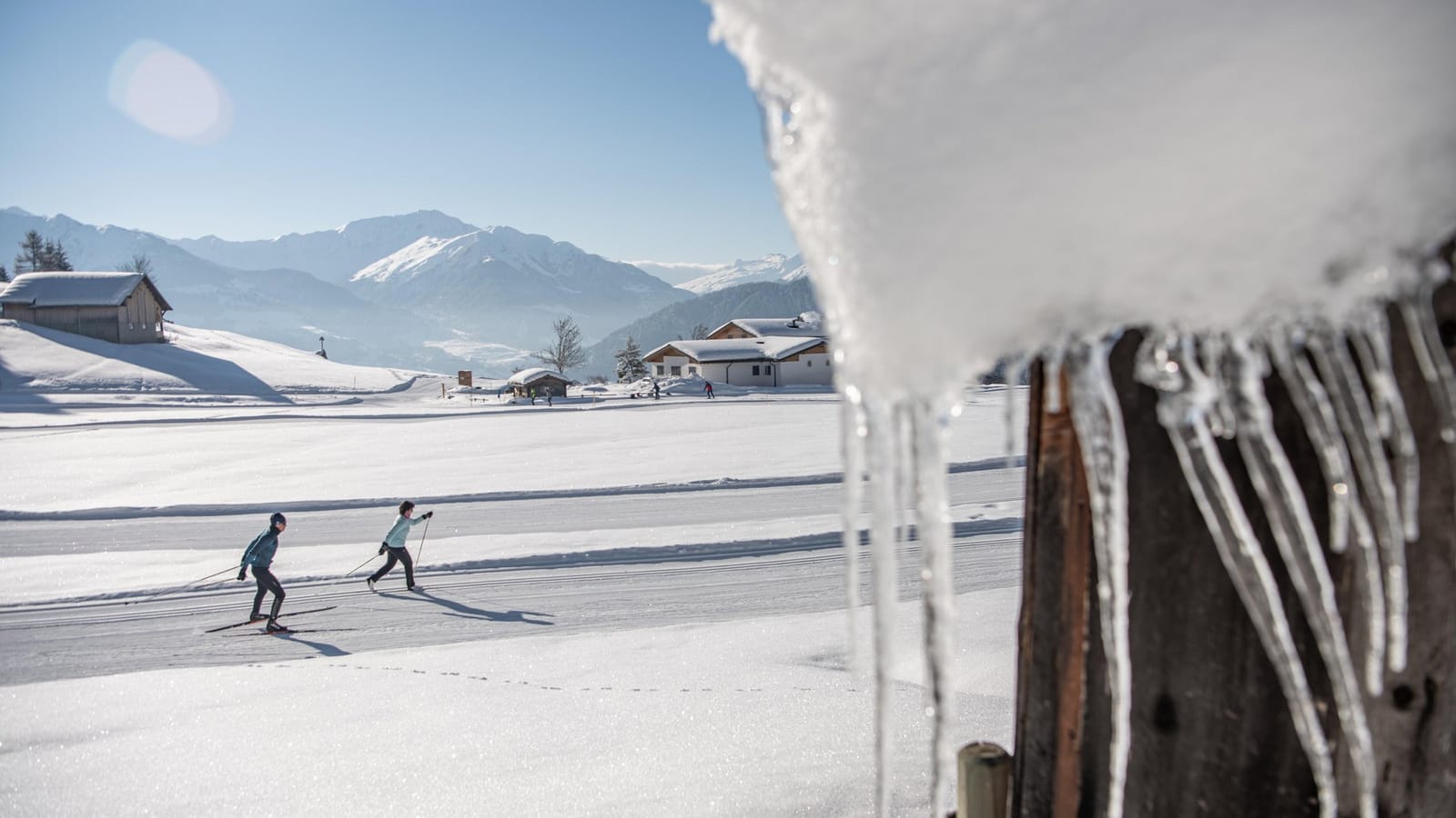 Zwei Langläufer auf der Loipe im Sonnenschein