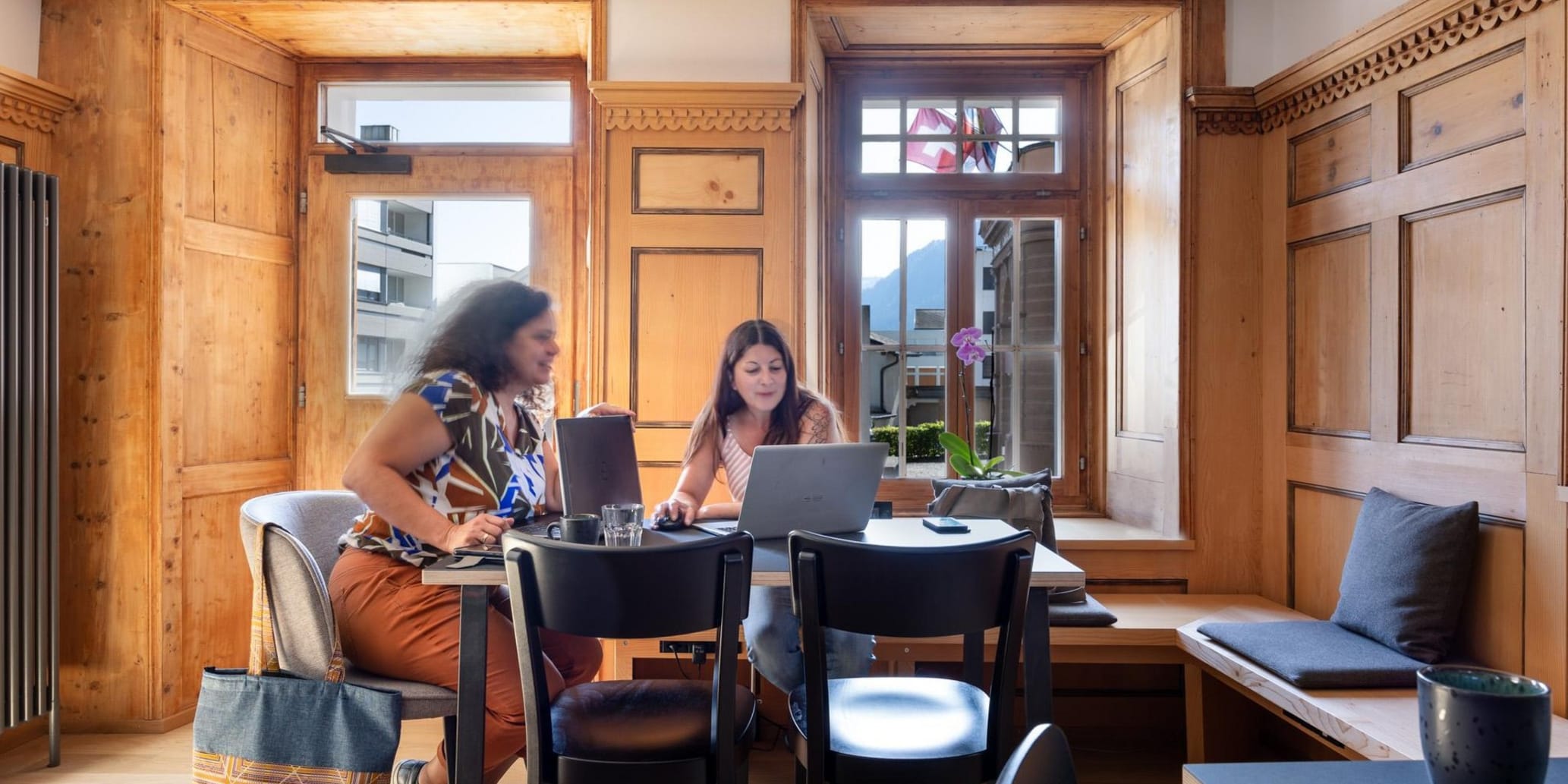 Zwei Frauen arbeiten im Hotel am Tisch mit Laptops