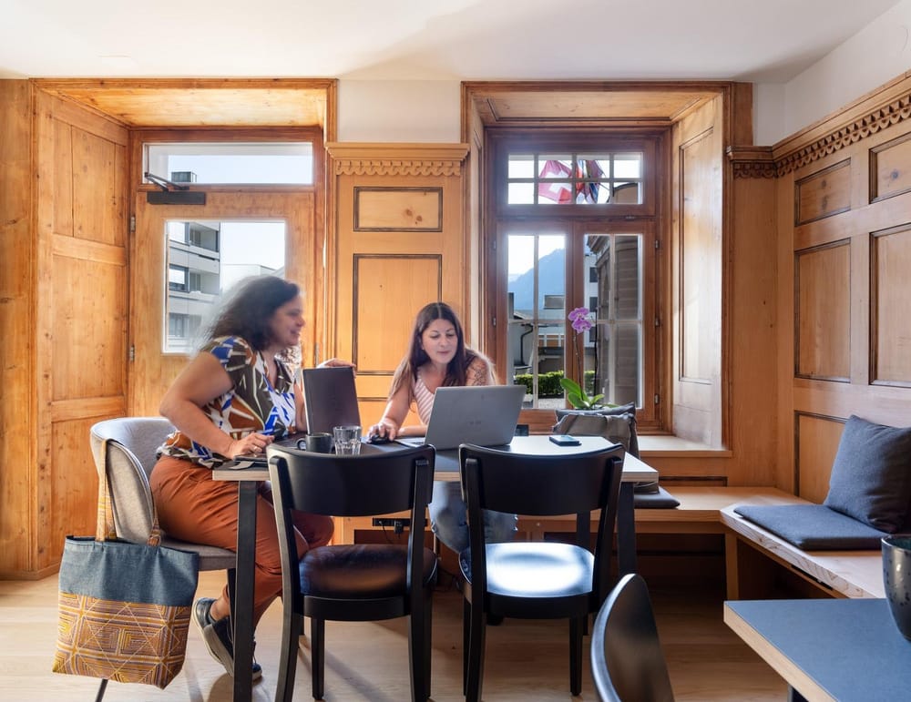 Zwei Frauen arbeiten im Hotel am Tisch mit Laptops