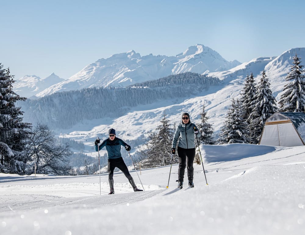 Paar auf Langlaufski in der verschneiten Surselva