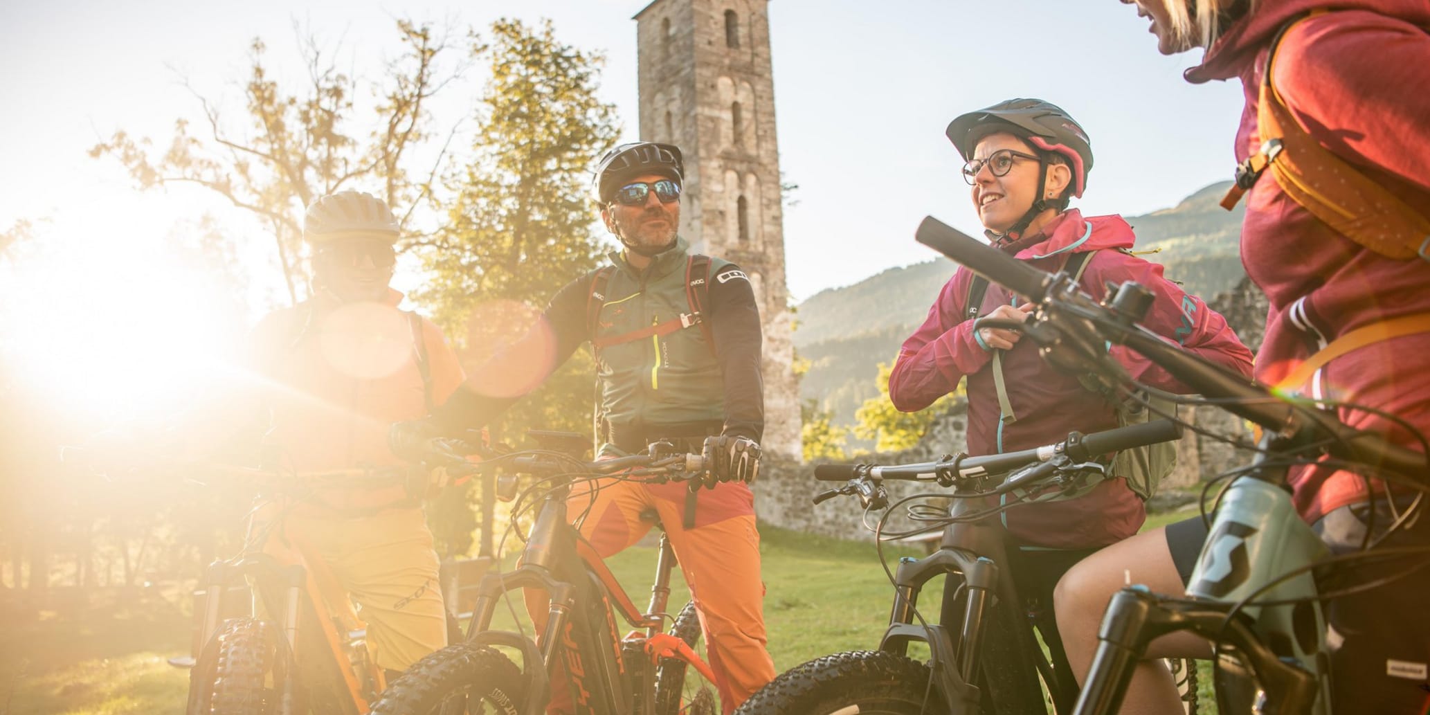 Mountainbiker besprechen sich im Hintergrund Turm