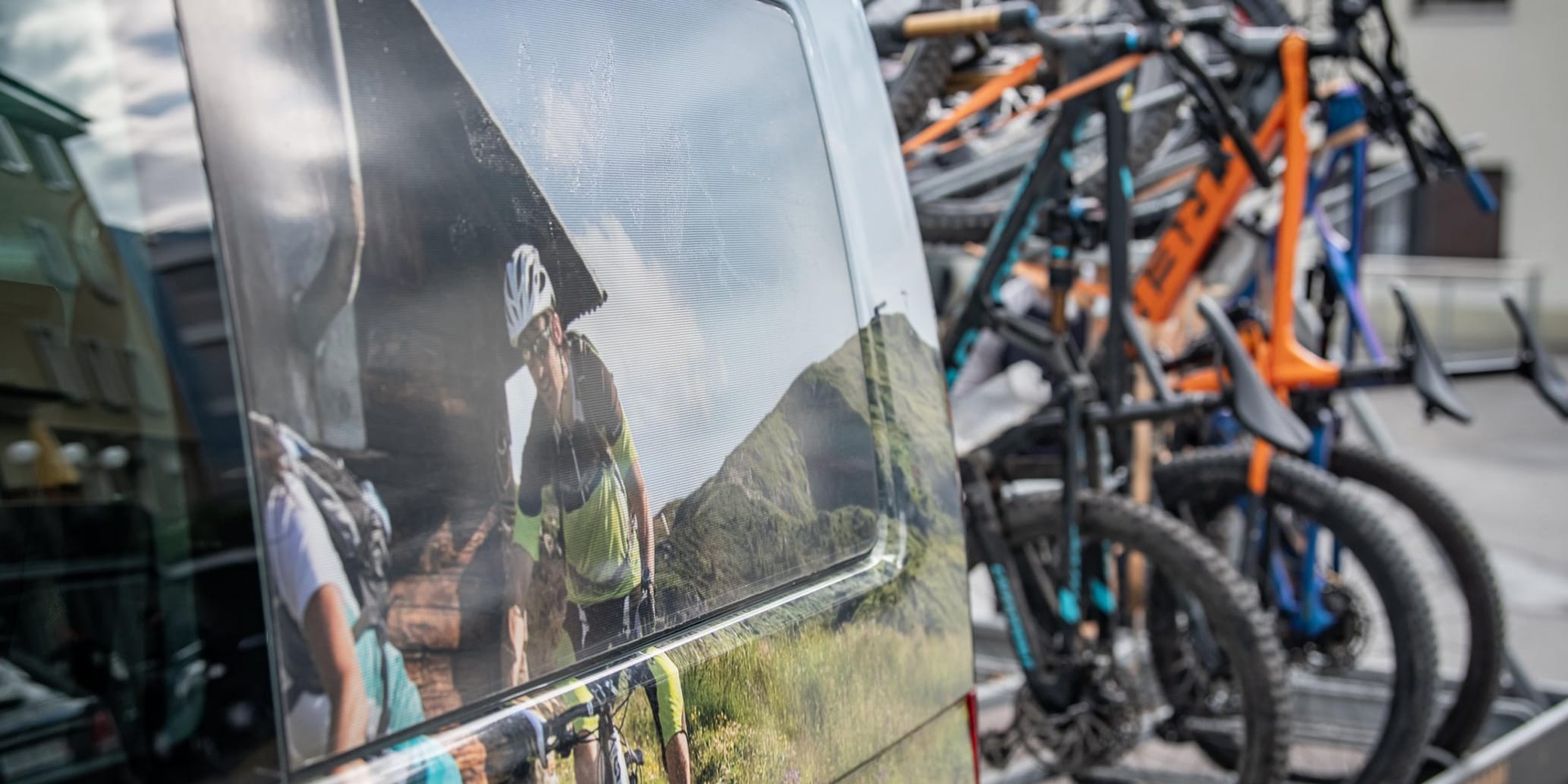 Schwarzer Bus mit Anhänger und viele Bikes drauf