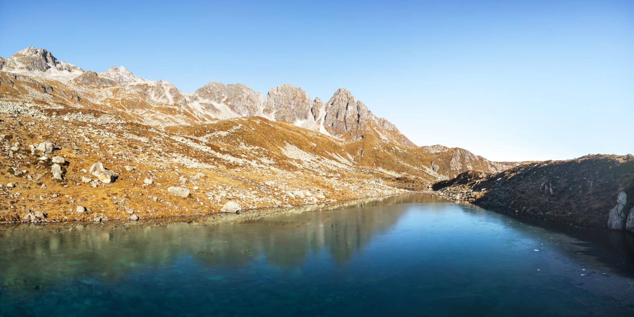 Klarer Bergsee eingerahmt von Bergen im Sommer