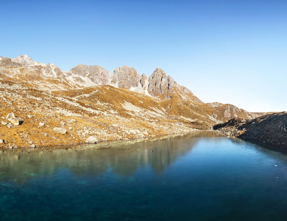 Klarer Bergsee eingerahmt von Bergen im Sommer