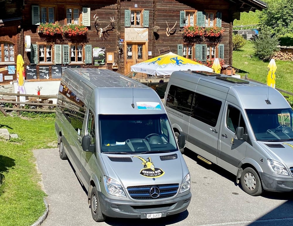 Zwei Shuttlebusse stehen vor Bergrestaurant im Sommer
