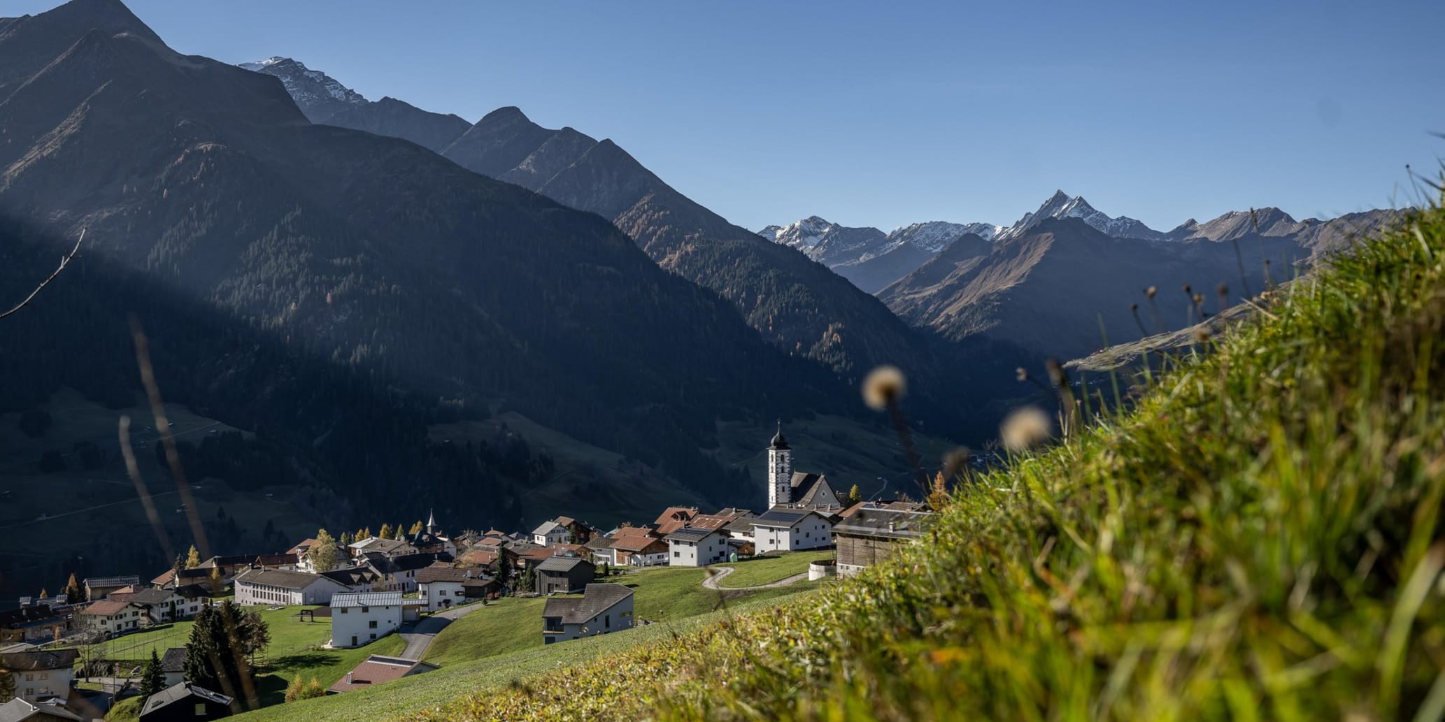 Hinter Wiese hervor Blick auf einen Teil des Dorfes im Sommer