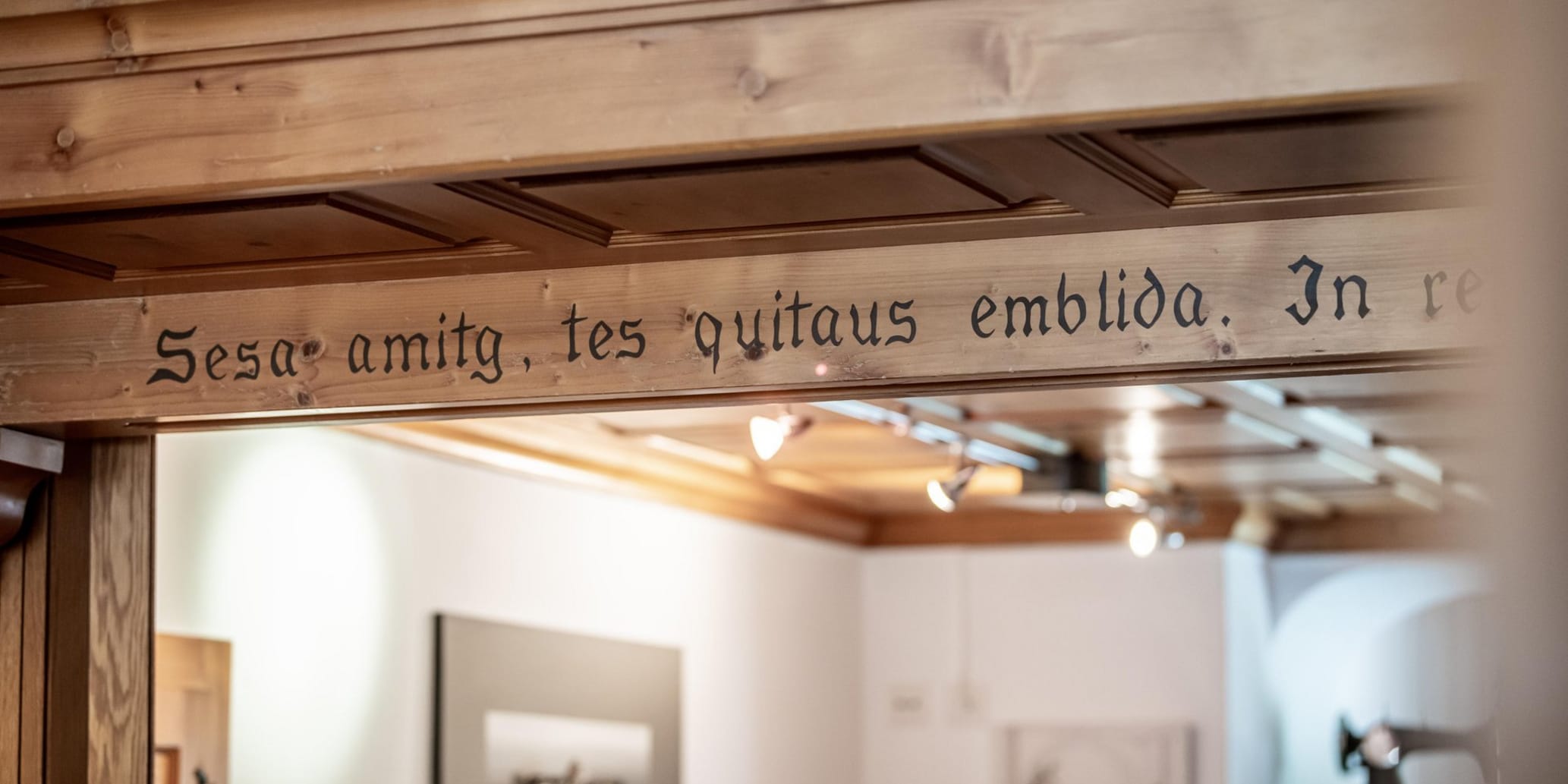 Innenraum mit romanischer Schrift auf Holzbalken oben an der Decke