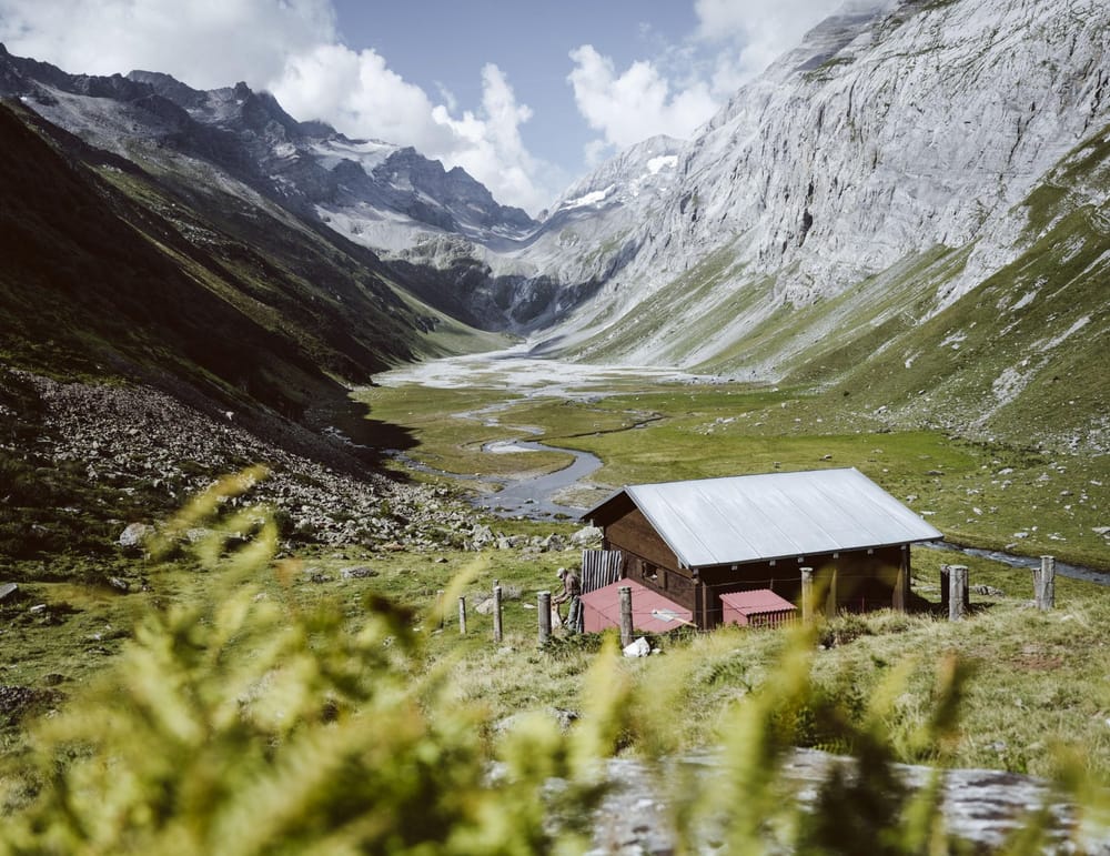 Berghütte auf Platteau, links und rechts Berge