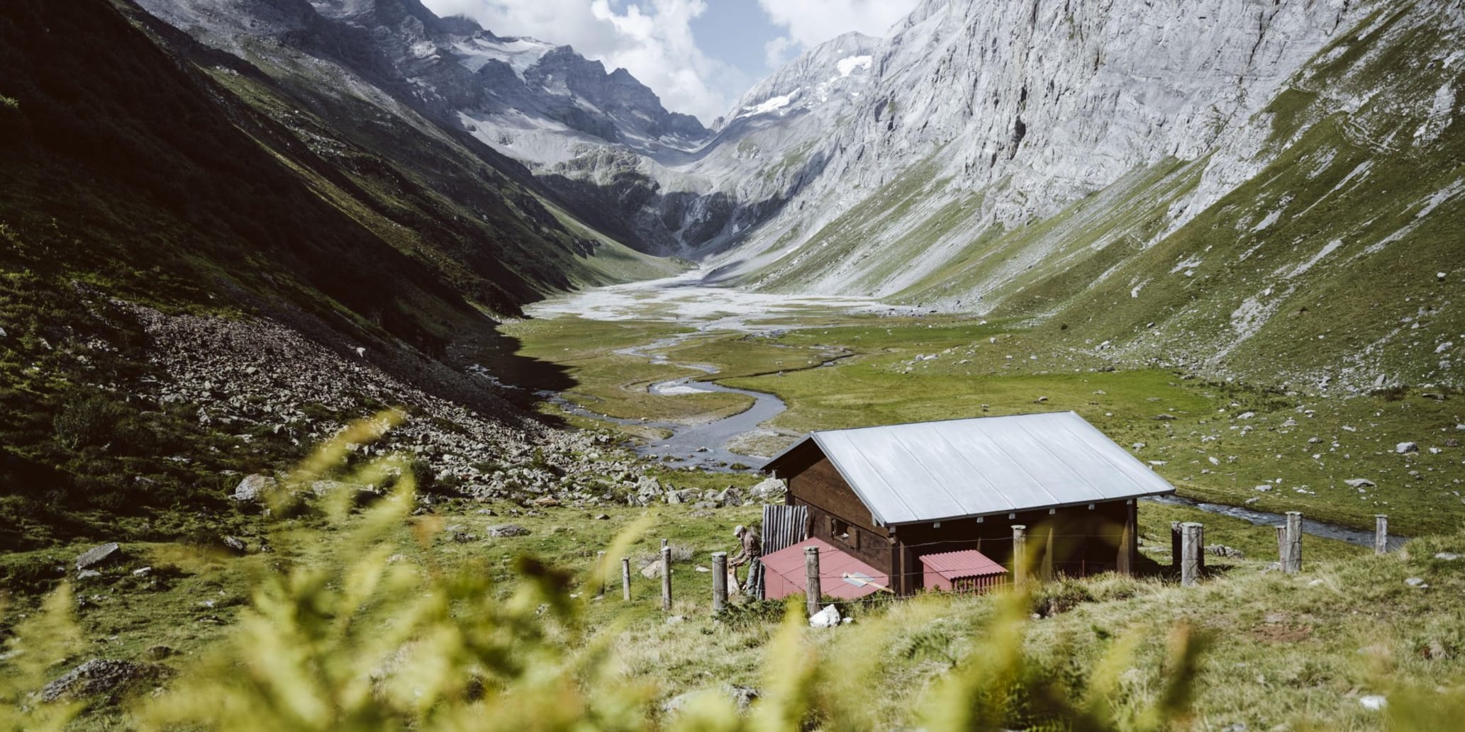 Berghütte auf Platteau, links und rechts Berge