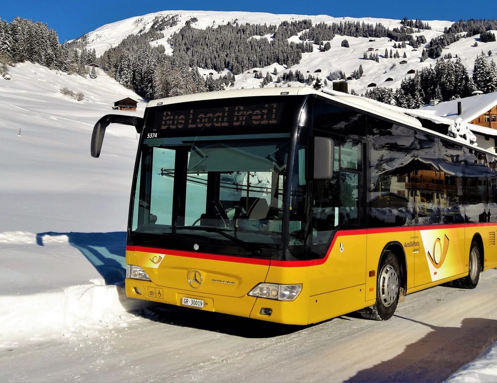 Postauto im Winter auf Strasse Ausserorts